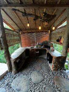 uma grande mesa de madeira em uma sala com pedras em Cabin swargana em Tampaksiring