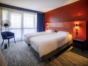 une chambre d'hôtel avec deux lits et une chaise dans l'établissement Mercure Thalasso & Spa Port Fréjus, à Fréjus