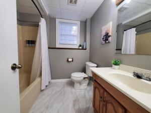 a bathroom with a sink and a toilet and a mirror at Quiet 3BR 2BA Near Mall, Shopping Centers, and I-94 in Eau Claire +20 photos