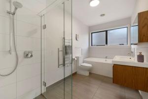 a bathroom with a shower and a toilet and a sink at Modern Luxe Jacks Point Living in Queenstown Airport