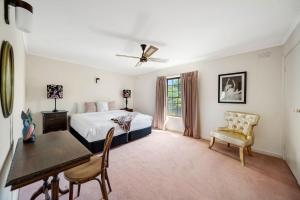 a bedroom with a bed and a table and chairs at Hunter House - Castlemaine in Castlemaine