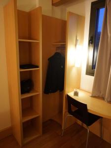 a small room with a desk and a closet at Ibis Girona in Girona