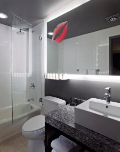 a bathroom with a white toilet and a red umbrella on the wall at Acme Hotel Company Chicago in Chicago