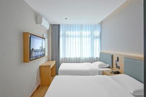 a hotel room with two beds and a television at Huayi Select Hotel Liujiayao Subway Station Hengliutiao Branch in Beijing