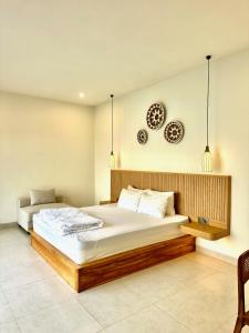 a bedroom with a large bed and two plates on the wall at Villas Topazio and Opalo -- Gateway to Uluwatu beaches in Uluwatu