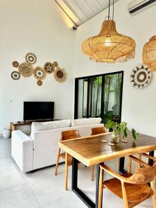 a living room with a white couch and a wooden table at Villas Topazio and Opalo -- Gateway to Uluwatu beaches in Uluwatu