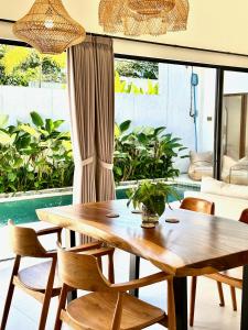 a dining room with a wooden table and chairs at Villas Topazio and Opalo -- Gateway to Uluwatu beaches in Uluwatu