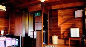 a room with a bed and a wooden wall at Ma-Oya Retreat in Pinnawala
