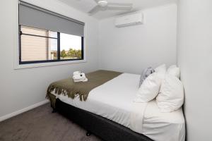 una camera da letto con un letto con lenzuola bianche e una finestra di BIG4 Casino Holiday Park a Casino Altre 44 foto