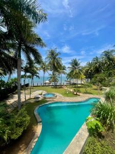 にあるAthaya Beachside Villaのヤシの木と海を背景にしたプール