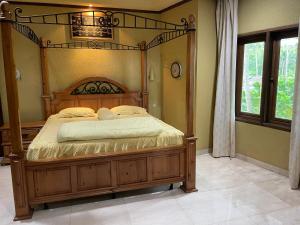 a bedroom with a wooden bed in a room at Athaya Beachside Villa in Kadujulang