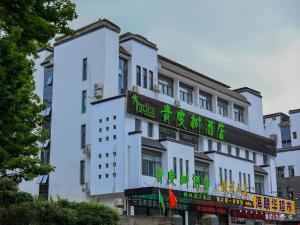 a white building with a sign on it at Vatica Hotel Huangshan South Gate Terminal Station in Huangshan Scenic Area