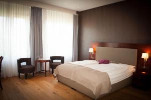una camera da letto con un letto, due sedie e un tavolo di Romantik Hotel Beau Rivage Weggis a Weggis