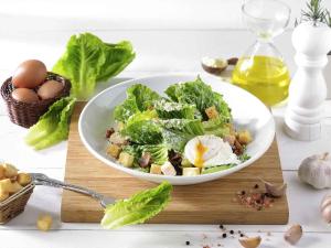 a bowl of salad on a cutting board with eggs and lettuce at Ibis Bangkok Sukhumvit 4 in Bangkok
