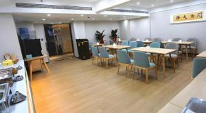 洛陽市にあるGreenTree Inn Luoyang Railway Station Wangfujing Wangcheng Parkの部屋にテーブルと椅子があるレストラン