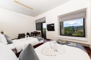a hotel room with two beds and a large window at Luang Prabang View Hotel in Luang Prabang
