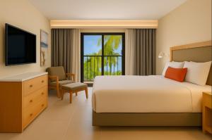 a hotel room with a bed and a television at Fiesta Americana Cancun Villas in Cancún