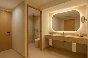 a bathroom with a sink and a toilet and a mirror at Fiesta Americana Cancun Villas in Cancún