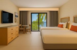 a hotel room with two beds and a television at Fiesta Americana Cancun Villas in Cancún