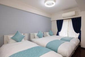 Dos camas en una habitación con azul y blanco. en Ocean Smile, 