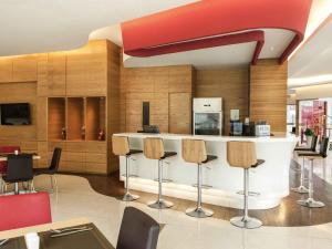 a lobby with a bar with chairs and a kitchen at Ibis Balikpapan in Balikpapan