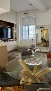 a living room with a glass table and chairs at Heart of Sydney CBD Chic One Bedroom Apartment with Pool on Bridge Street in Sydney
