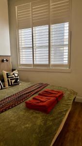 a bedroom with a bed with red blankets on it at Heart of Sydney CBD Chic One Bedroom Apartment with Pool on Bridge Street in Sydney