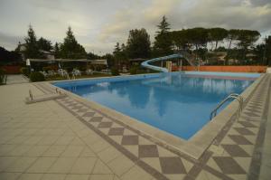 a large blue swimming pool with a slide at La Vignola Country Hotel in Ceprano