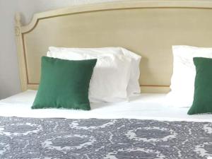 Una cama con almohadas verdes y blancas. en Valentina's House, en Porto da Cruz