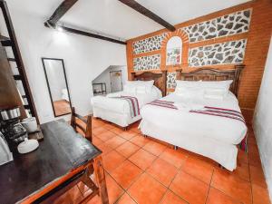 a bedroom with two beds and a table in a room at Colonial House 8 rooms and private parking in Antigua Guatemala in Antigua Guatemala