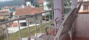 a rocking chair sitting on the balcony of a house at VHP luxury cottage kodaikkanal in Kodaikānāl +1 photo