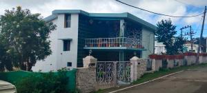 a blue and white house with a fence at VHP luxury cottage kodaikkanal in Kodaikānāl
