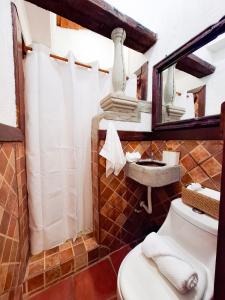 a bathroom with a toilet and a sink and a mirror at Colonial House 8 rooms and private parking in Antigua Guatemala in Antigua Guatemala