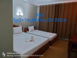 two beds in a hotel room with towels on them at C T hotel in Banlung +3 photos