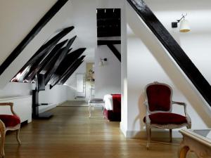 une pièce avec un escalier avec des chaises et un lit dans l'établissement Cour du Corbeau Hotel Strasbourg - MGallery Collection, à Strasbourg 51 autres photos