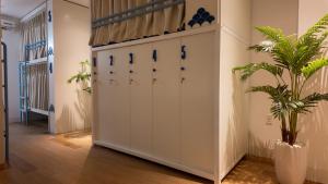 a locker room with white lockers and a plant at Mik Stay in Danang