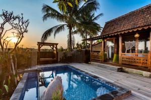 una villa con piscina y una casa en Kamania Villa Ubud by Dhananjaya Hospitality, en Tampaksiring