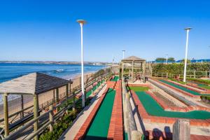 a boardwalk next to the beach and the ocean at Harmonie in Hartenbos in Mossel Bay