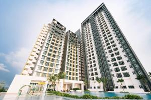 two tall buildings with palm trees in front of them at Metropol by BRB in Bukit Mertajam
