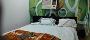 a bed with a remote control on top of it at Hotel O Priya in Indraprast