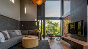 a living room with a couch and a large window at Rinzan Chalet by Elite Havens in Niseko