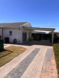 ein weißes Haus mit Terrasse und Veranda in der Unterkunft TimeOut 1 in Yzerfontein