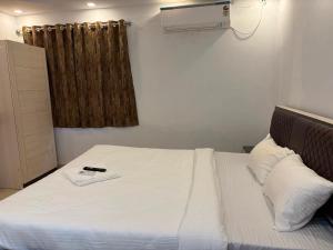 a bedroom with a white bed and a window at Hotel O Acroview in Ballygunge