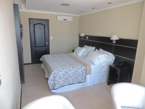 Habitación de hotel con cama y puerta negra en Apart Belgrano en Posadas