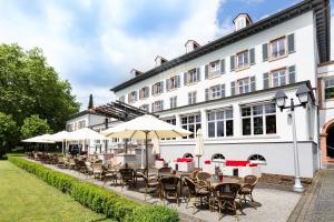 a row of tables and chairs in front of a building at Kurhaushotel Bad Salzhausen in Bad Salzhausen