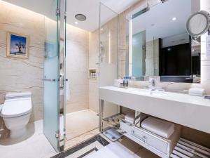 a bathroom with a sink and a toilet and a mirror at Pullman Guiyang in Guiyang