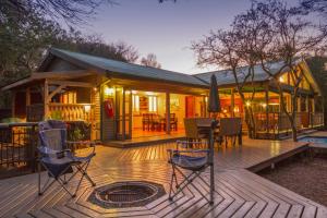 a wooden deck with chairs and a house at Thornwood in KwaNibela