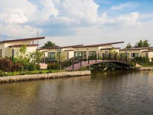 a bridge over a river in front of a building at Bua Tara Resort in Nong Prue