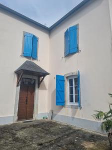 a white house with blue shutters and a door at Belle Chambre privée entre mer et montagne in Moncayolle-Larrory-Mendibieu