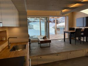a kitchen and dining room with a table and a view at Tiny Barrhorn in Grächen